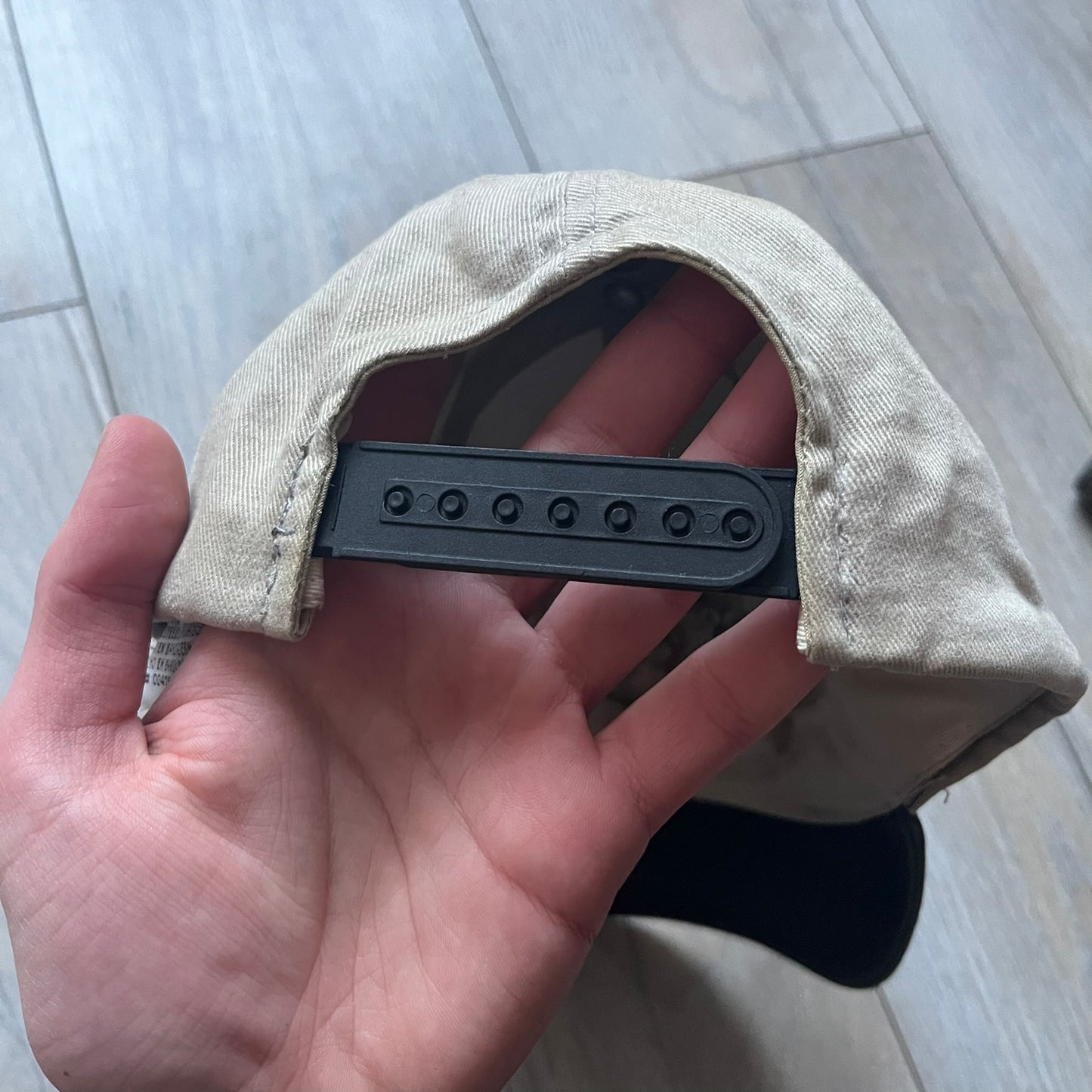 Warner Bros Taz 1998 Baseball Cap is a two-tone beige and black cap featuring an embroidered Warner Bros logo on the front, positioned next to a detailed Taz (Tasmanian Devil) character graphic. Inside, the cap retains its original 1998 Warner Bros tag. The adjustable back strap has been reattached and stitched.