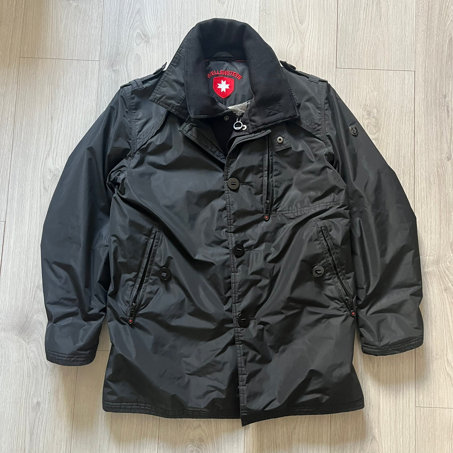 The Wellensteyn Mercury Black Winter Jacket combines premium function with tailored elegance. Crafted from TiSaAirTec fabric, it offers a smooth, matte finish that is waterproof, windproof, and built for temperatures from 0 to -20 °C. Features include a removable inner jacket with a high knit collar, multiple secure pockets, back vents, and a quilted lining for warmth. A signature of German engineering and timeless outerwear design.