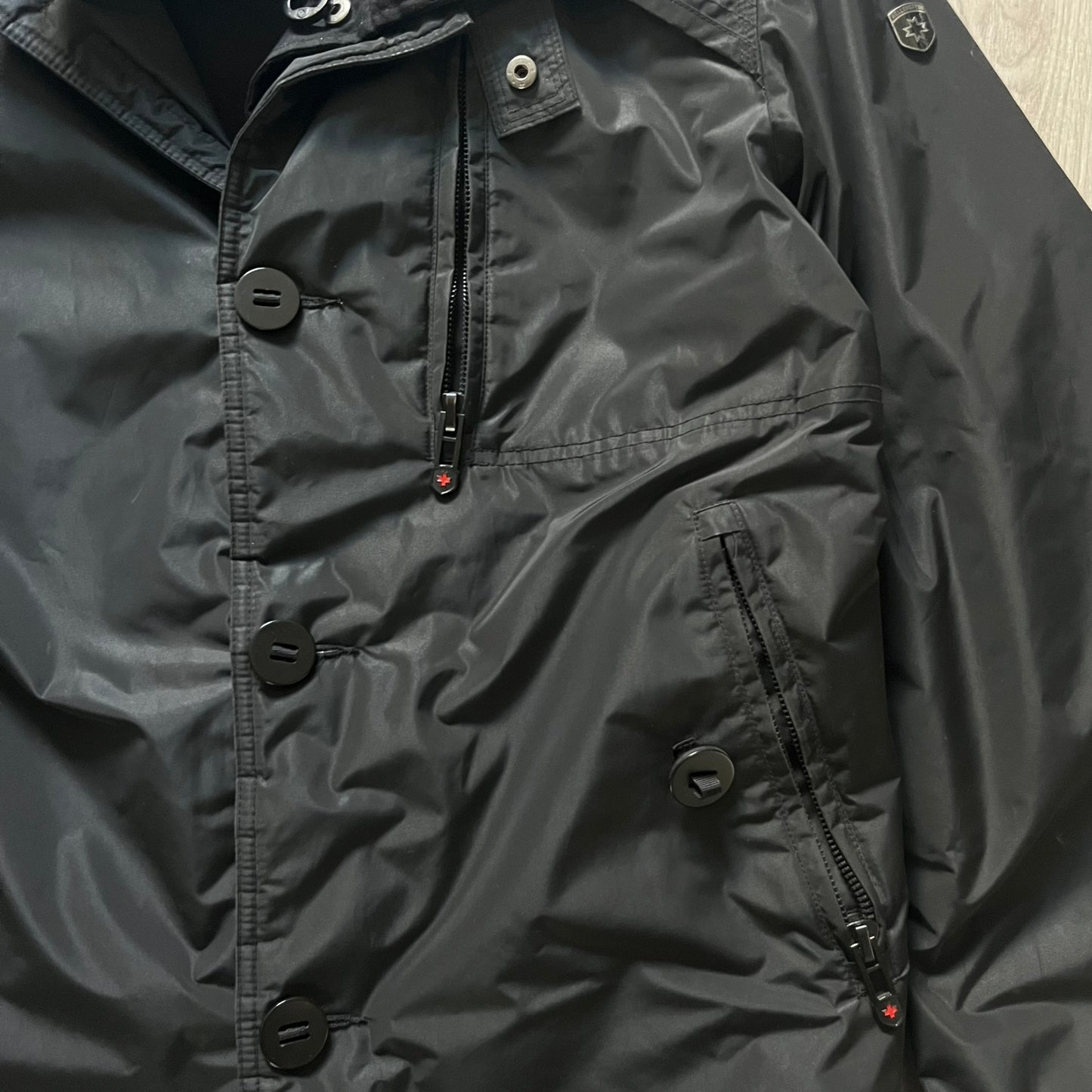 The Wellensteyn Mercury Black Winter Jacket combines premium function with tailored elegance. Crafted from TiSaAirTec fabric, it offers a smooth, matte finish that is waterproof, windproof, and built for temperatures from 0 to -20 °C. Features include a removable inner jacket with a high knit collar, multiple secure pockets, back vents, and a quilted lining for warmth. A signature of German engineering and timeless outerwear design.