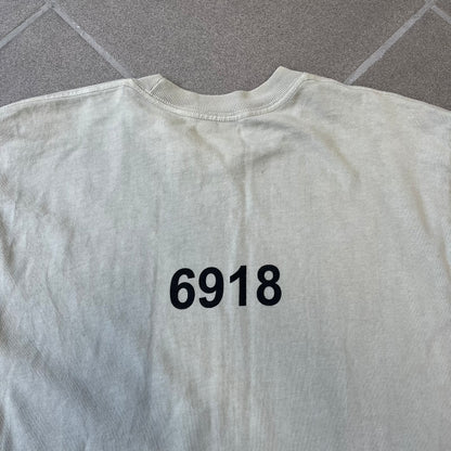 Longsleeve tee from the FW18 Yeezy x Pornhub collection, released 09/07/2018. Vapor color, featuring a front illustration of painted Mia Malkova with her name above and “Hottest Female Ass” below. Back has the numbers “6918” (futuristic theme set in the year 6918). Includes printed Pornhub tag and YEEZY wash tag, part of a limited run commemorating the 2018 Pornhub Awards.