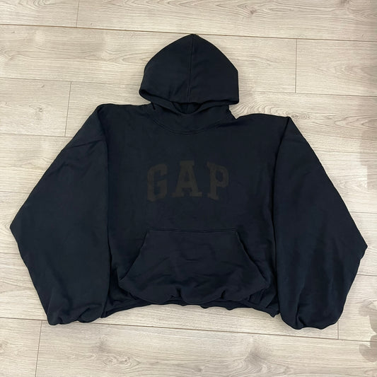 Yeezy GAP Engineered by Balenciaga Dove Hoodie in washed black, produced as part of the three-way Yeezy, GAP, and Balenciaga collaboration. Features a boxy, oversized fit with a slightly darker oversized GAP logo printed on the front and a large white dove graphic on the back. Each hoodie shows natural variation in wash, tone, and texture, consistent with the production process used for this release, from LosAngelesArchive.