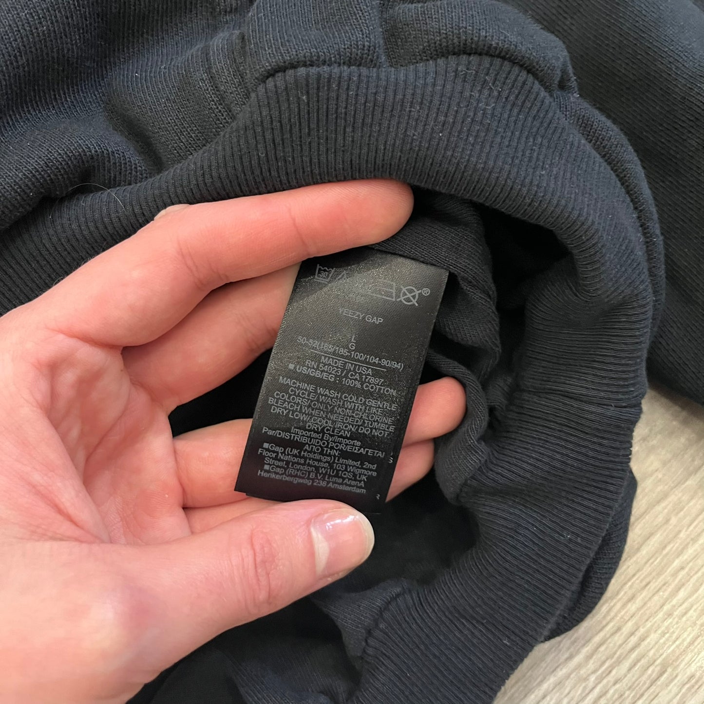 Yeezy GAP Engineered by Balenciaga Dove Hoodie in washed black, produced as part of the three-way Yeezy, GAP, and Balenciaga collaboration. Features a boxy, oversized fit with a slightly darker oversized GAP logo printed on the front and a large white dove graphic on the back. Each hoodie shows natural variation in wash, tone, and texture, consistent with the production process used for this release, from LosAngelesArchive.