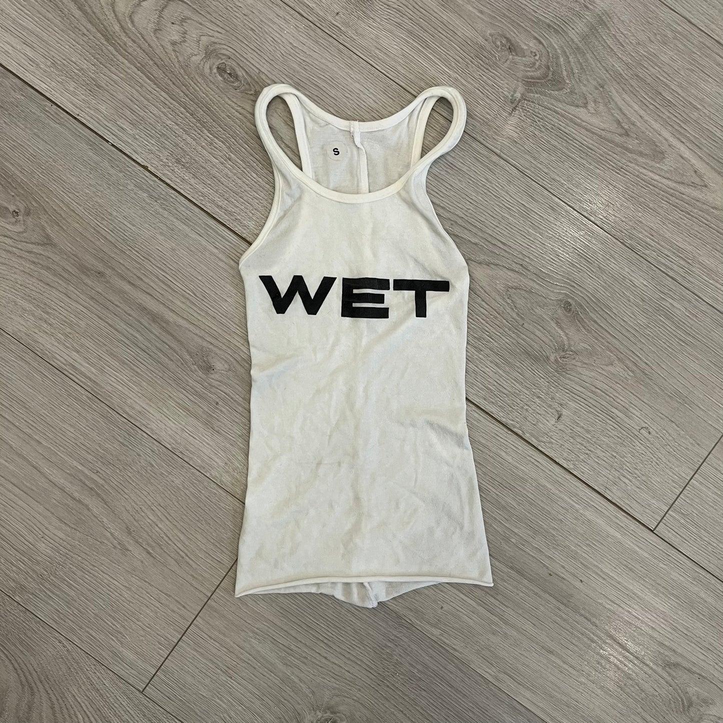 Yeezy x Mowalola WET Tank Top in white cotton with the big black “WET” graphic across the chest. The fabric is highly stretchy, giving it a flexible and sculpted fit.