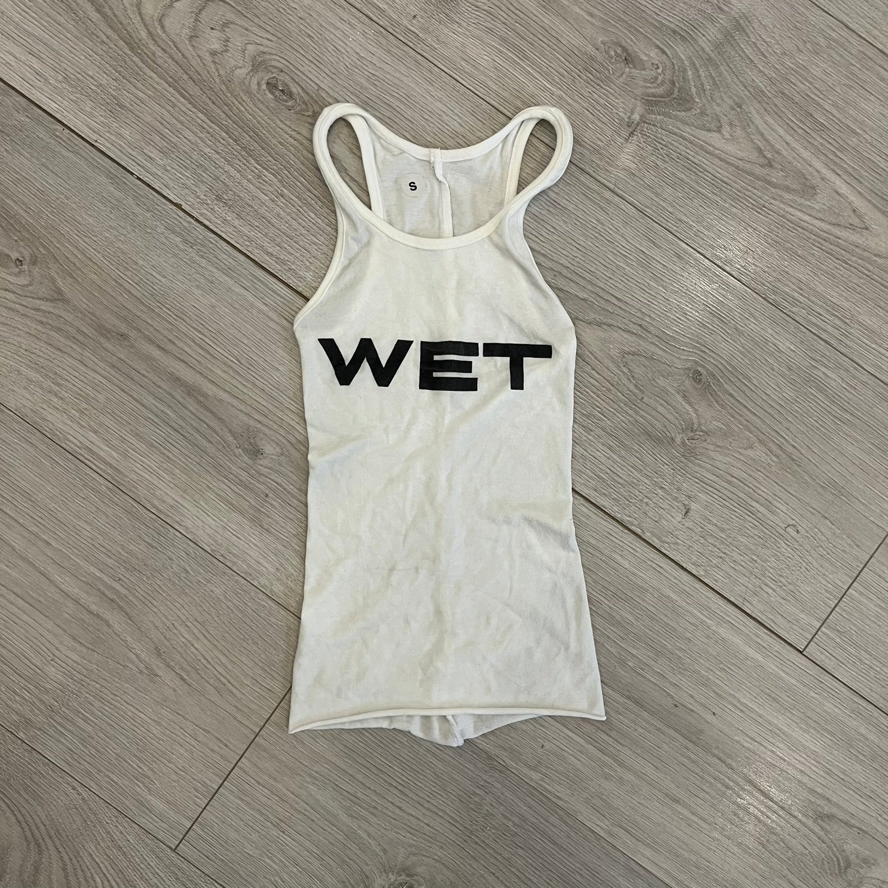 Yeezy x Mowalola WET Tank Top in white cotton with the big black “WET” graphic across the chest. The fabric is highly stretchy, giving it a flexible and sculpted fit.
