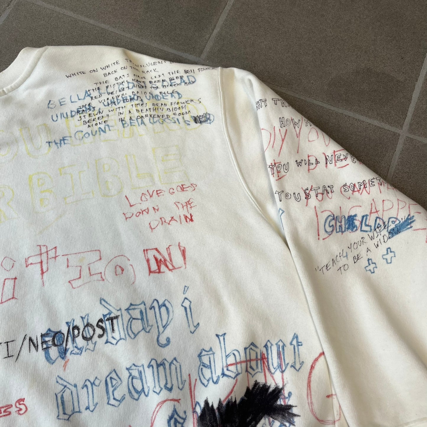 Yeezy Season 5 Scribbled Adidas Crewneck by ERD features an oversized, boxy silhouette in the Arctic colorway. The 100% cotton Adidas crewneck has handwritten-style printed graphics and phrases across the garment, including a embroidered Adidas Three Stripes logo on the chest. It was made in Italy and designed by Henri Alexander Levy from Enfants Riches Déprimés.