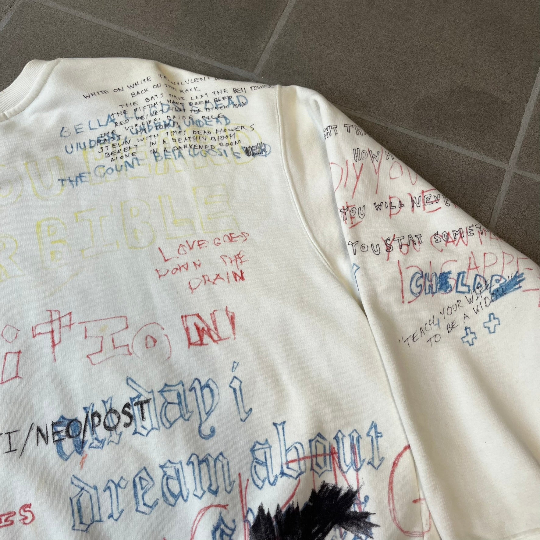 Yeezy Season 5 Scribbled Adidas Crewneck by ERD features an oversized, boxy silhouette in the Arctic colorway. The 100% cotton Adidas crewneck has handwritten-style printed graphics and phrases across the garment, including a embroidered Adidas Three Stripes logo on the chest. It was made in Italy and designed by Henri Alexander Levy from Enfants Riches Déprimés.