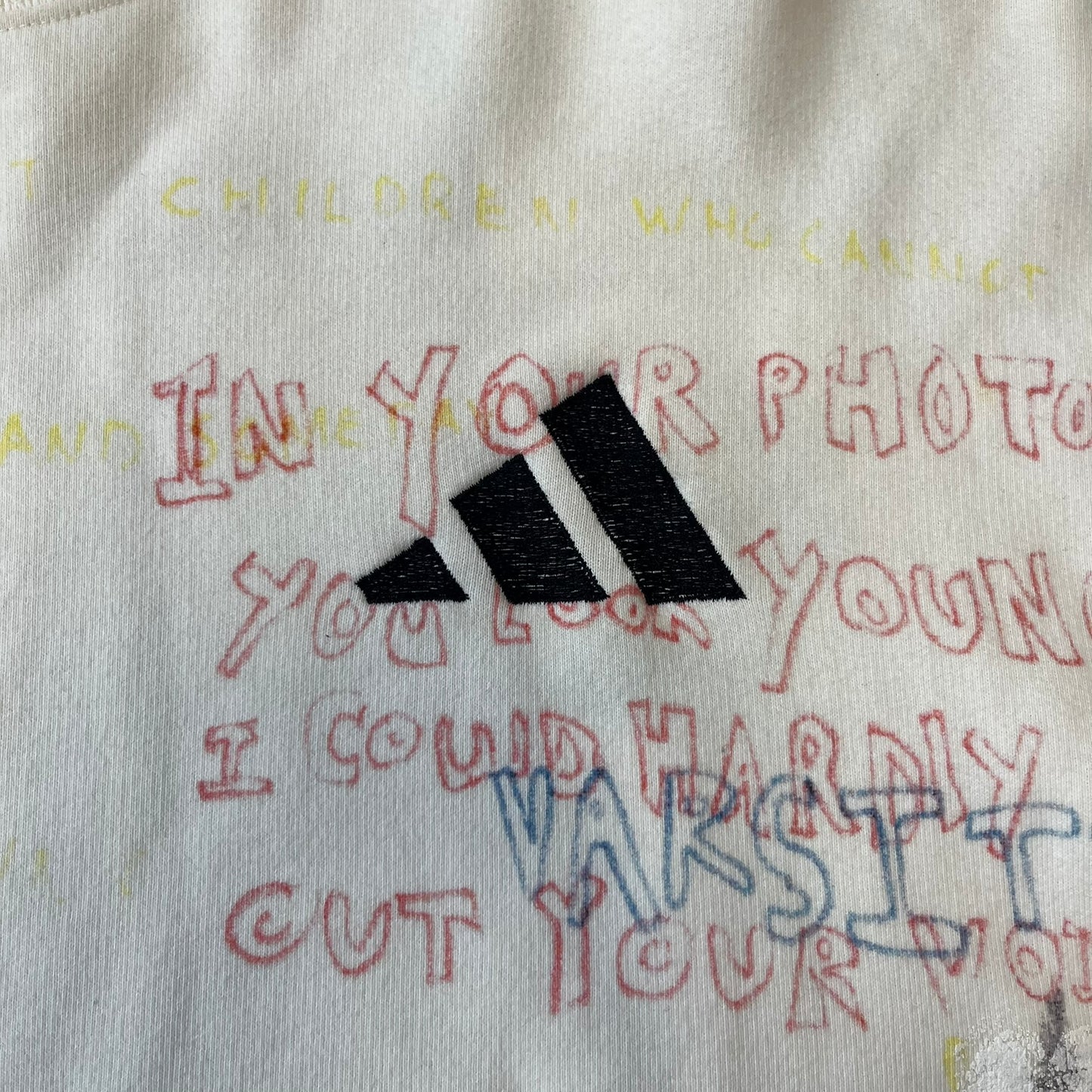 Yeezy Season 5 Scribbled Adidas Crewneck by ERD features an oversized, boxy silhouette in the Arctic colorway. The 100% cotton Adidas crewneck has handwritten-style printed graphics and phrases across the garment, including a embroidered Adidas Three Stripes logo on the chest. It was made in Italy and designed by Henri Alexander Levy from Enfants Riches Déprimés.