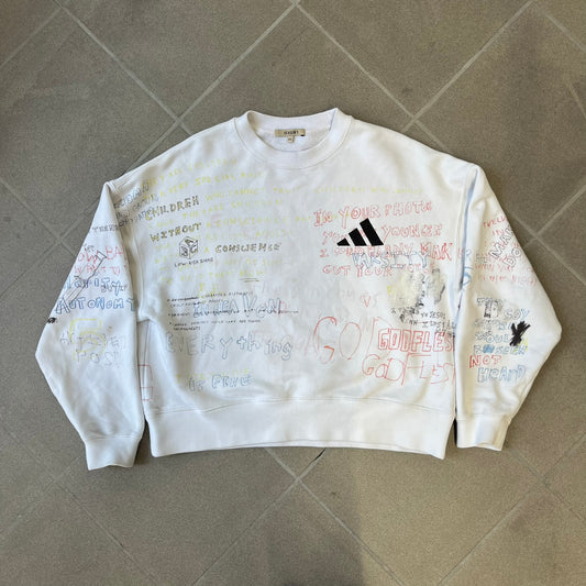 Yeezy Season 5 Scribbled Adidas Crewneck by ERD features an oversized, boxy silhouette in the Arctic colorway. The 100% cotton Adidas crewneck has handwritten-style printed graphics and phrases across the garment, including a embroidered Adidas Three Stripes logo on the chest. It was made in Italy and designed by Henri Alexander Levy from Enfants Riches Déprimés.