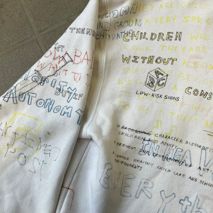 Yeezy Season 5 Scribbled Adidas Crewneck by ERD features an oversized, boxy silhouette in the Arctic colorway. The 100% cotton Adidas crewneck has handwritten-style printed graphics and phrases across the garment, including a embroidered Adidas Three Stripes logo on the chest. It was made in Italy and designed by Henri Alexander Levy from Enfants Riches Déprimés.