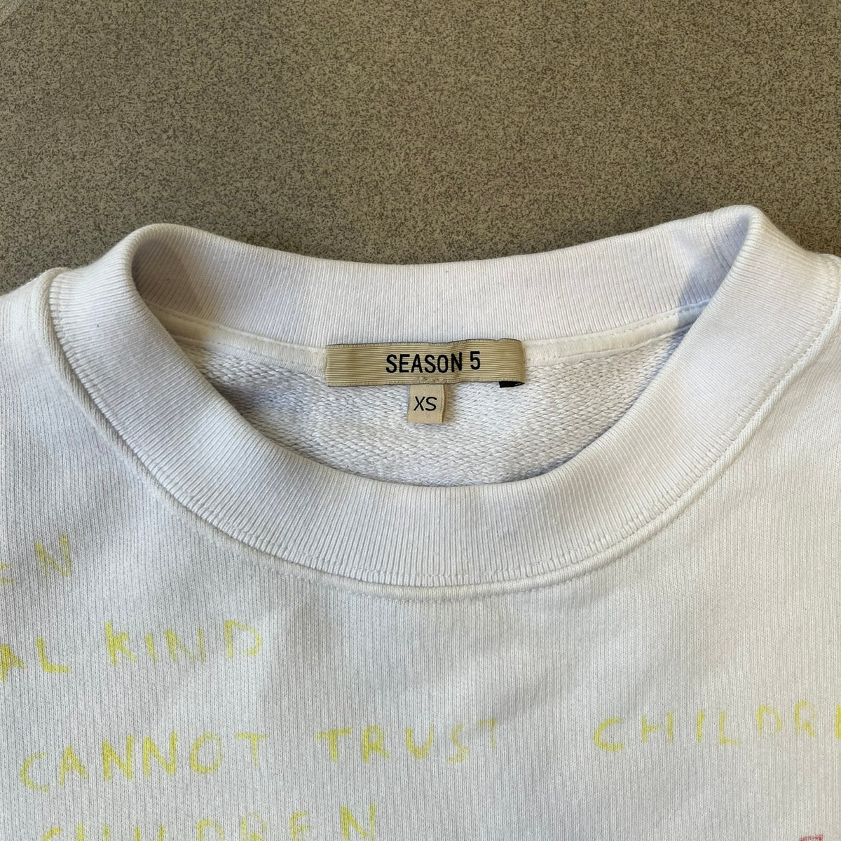 Yeezy Season 5 Scribbled Adidas Crewneck by ERD features an oversized, boxy silhouette in the Arctic colorway. The 100% cotton Adidas crewneck has handwritten-style printed graphics and phrases across the garment, including a embroidered Adidas Three Stripes logo on the chest. It was made in Italy and designed by Henri Alexander Levy from Enfants Riches Déprimés.