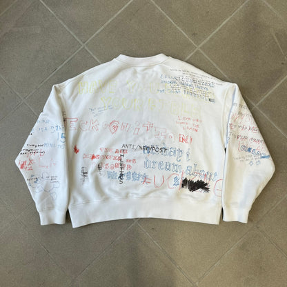 Yeezy Season 5 Scribbled Adidas Crewneck by ERD features an oversized, boxy silhouette in the Arctic colorway. The 100% cotton Adidas crewneck has handwritten-style printed graphics and phrases across the garment, including a embroidered Adidas Three Stripes logo on the chest. It was made in Italy and designed by Henri Alexander Levy from Enfants Riches Déprimés.