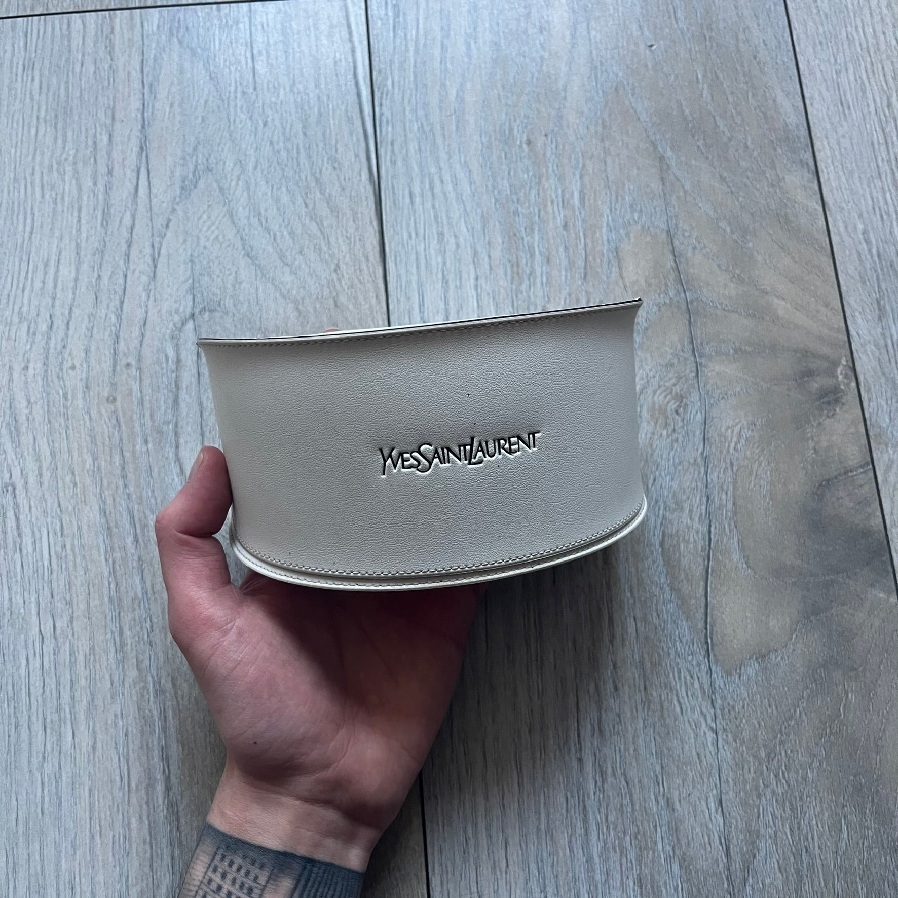 The Yves Saint Laurent 2007 Swirls 6412/S Sunglasses are an oversized model from 2007 with Category 3 sun protection. They feature oversized gradient grey lenses and burgundy (bordeaux) plastic frames, with silver-tone metal swirl details connecting the lenses to the temples. The temples are finished with a metal Yves Saint Laurent logo integrated into the swirl hardware. Made in Italy, with all original markings located on the inside. They come with a white leather YSL case.