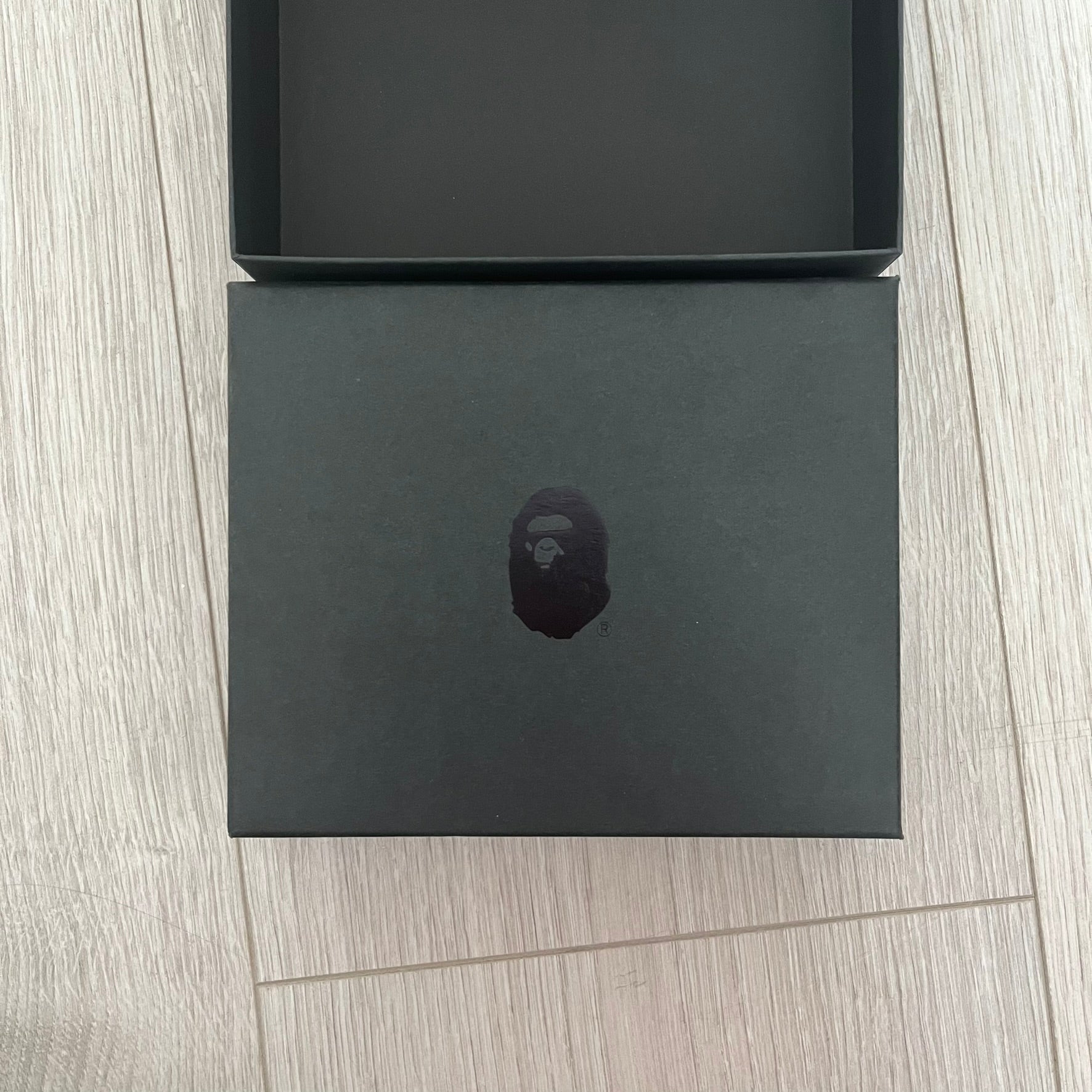 Black box with a BAPE logo on a wooden surface