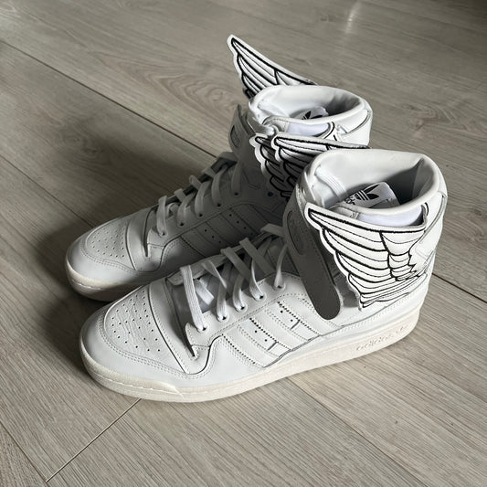 The Adidas Jeremy Scott Wings 4.0 Forum Hi launched on May 5, 2022, in a white and black colorway. Premium leather uppers highlight black stripes, heel tab, and Wings branding, while the high-top structure provides support with a padded collar and tongue. Equipped with a rubber herringbone outsole for grip, this limited edition release merges classic silhouette with JS design.