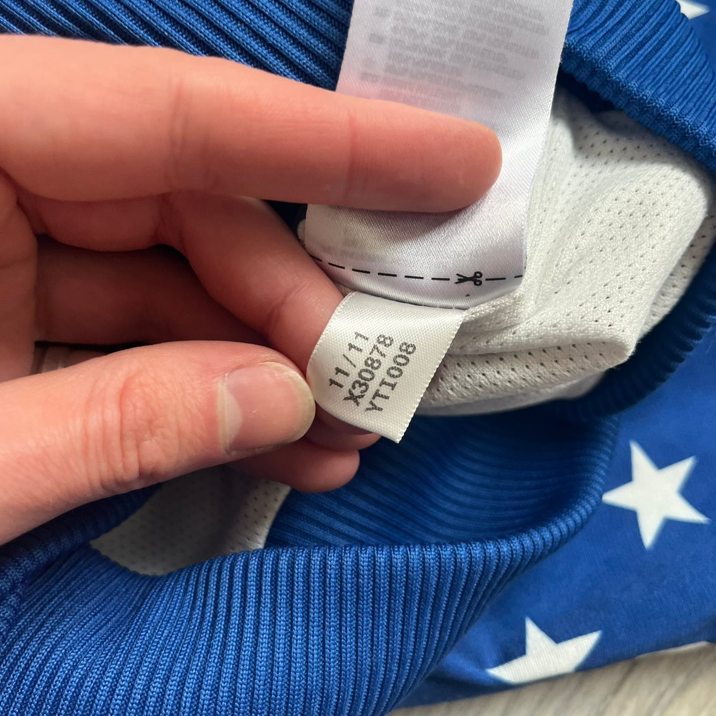 Adidas Originals Stars Blue Track Jacket is a blue zip-up track jacket featuring an all-over white star print. It includes white Adidas three-stripes along the sleeves and a small Adidas Originals patch on the chest. The design closely resembles star-pattern track jacket by Jeremy Scott for Adidas Originals.