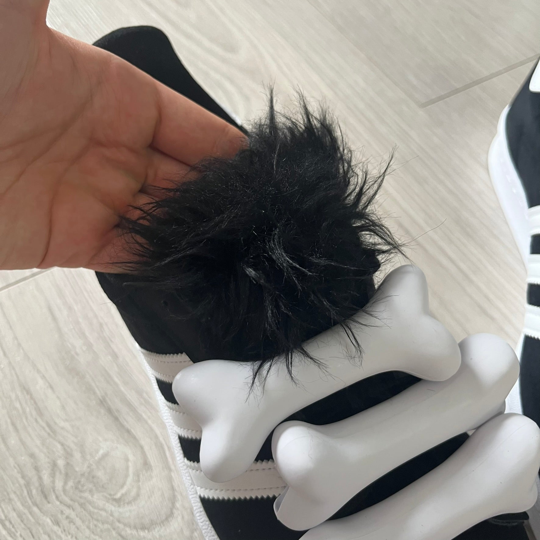 jeremy scott’s take on the adidas campus 80s includes black leather, serrated stripes, and unique faux fur tongues. detachable white bones on the laces add a customizable, standout touch. this 2023 release balances classic style with avant-garde details.
