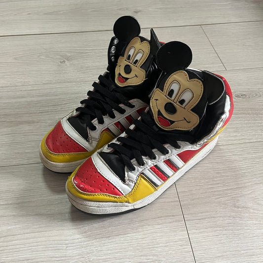 Pair of sneakers with cartoon character design on a wooden floor