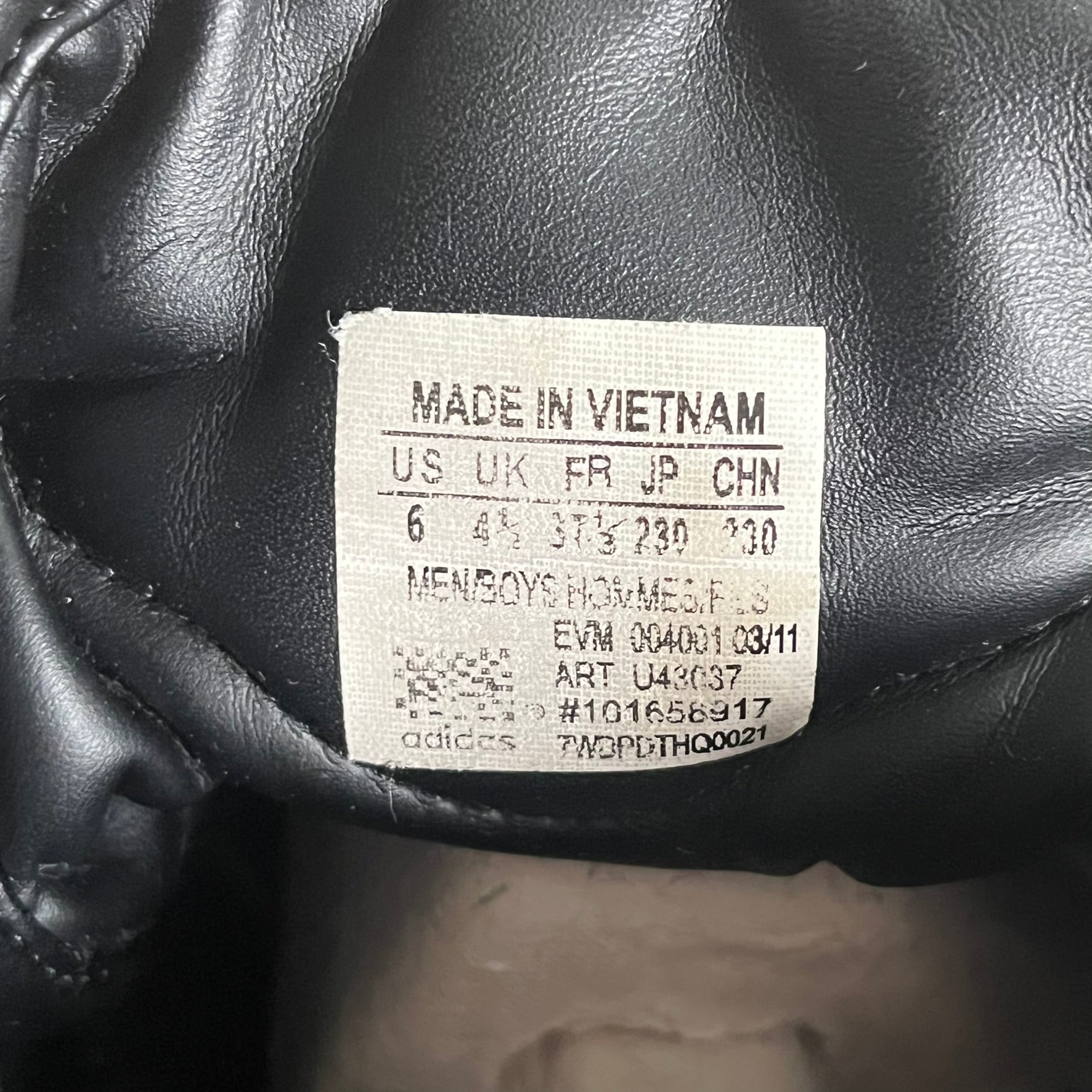 Label on a black leather product indicating 'Made in Vietnam' and other details.
