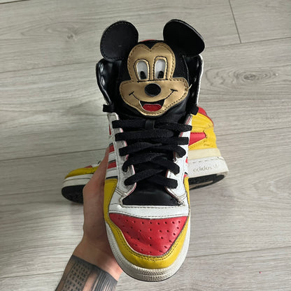 Sneaker with a cartoon face design on a wooden floor