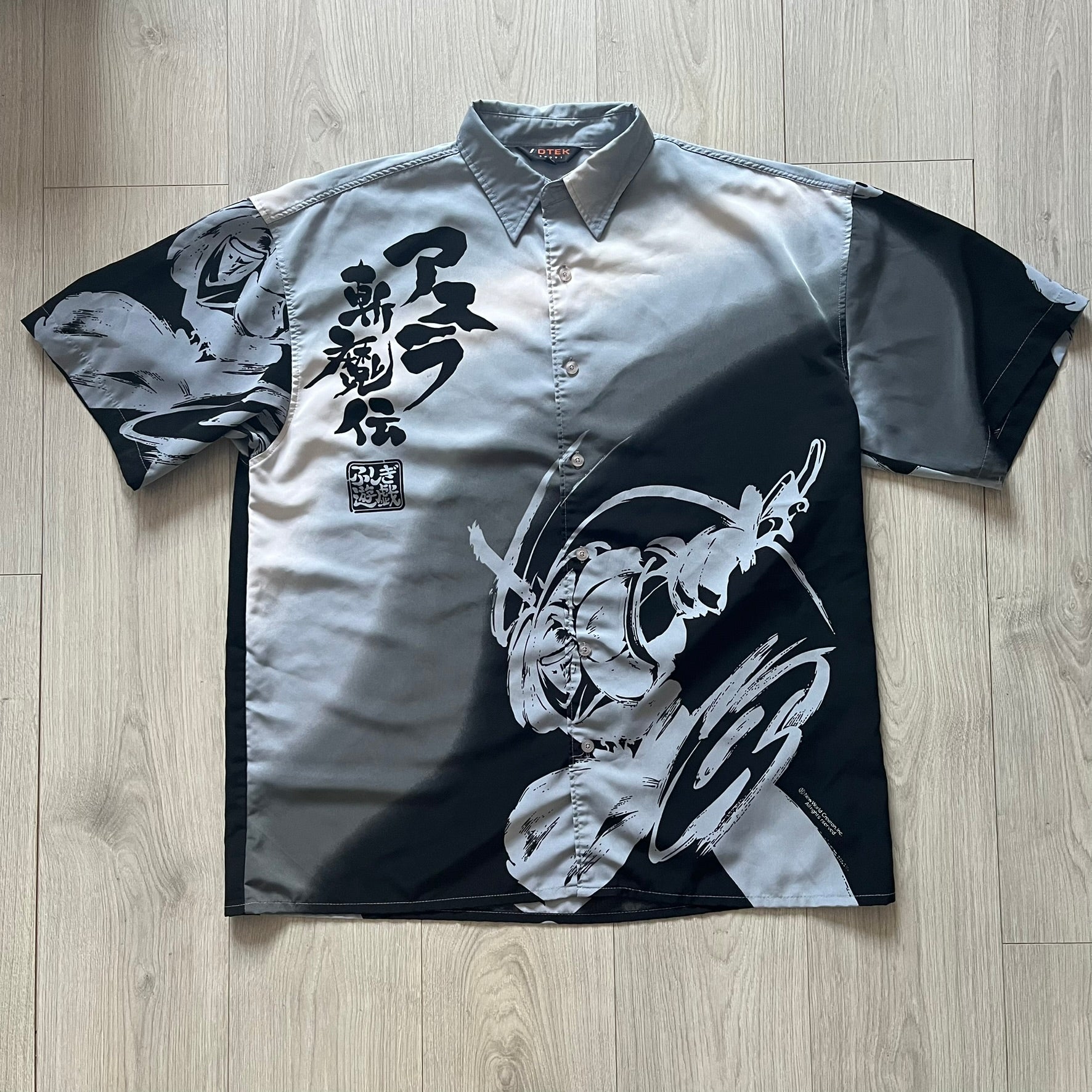 Short-sleeve shirt with black and white designs on a wooden floor