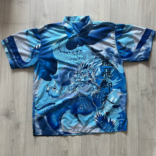 Blue and white shirt with dragon design on a wooden floor