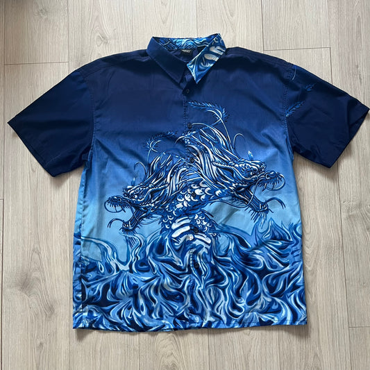 Blue shirt with dragon design on a wooden floor