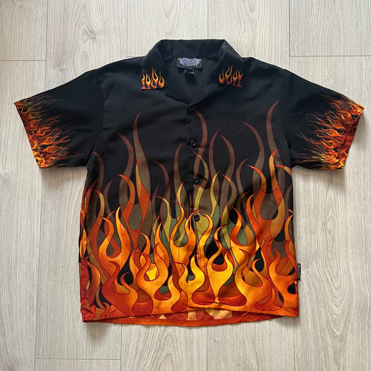 Black shirt with flame pattern on a wooden floor