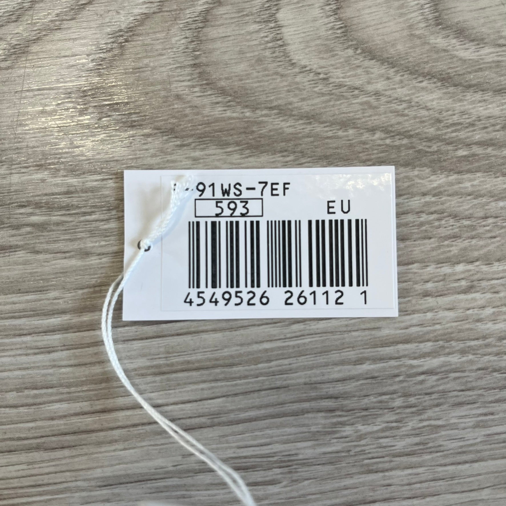 Product tag with barcode and text on a wooden surface