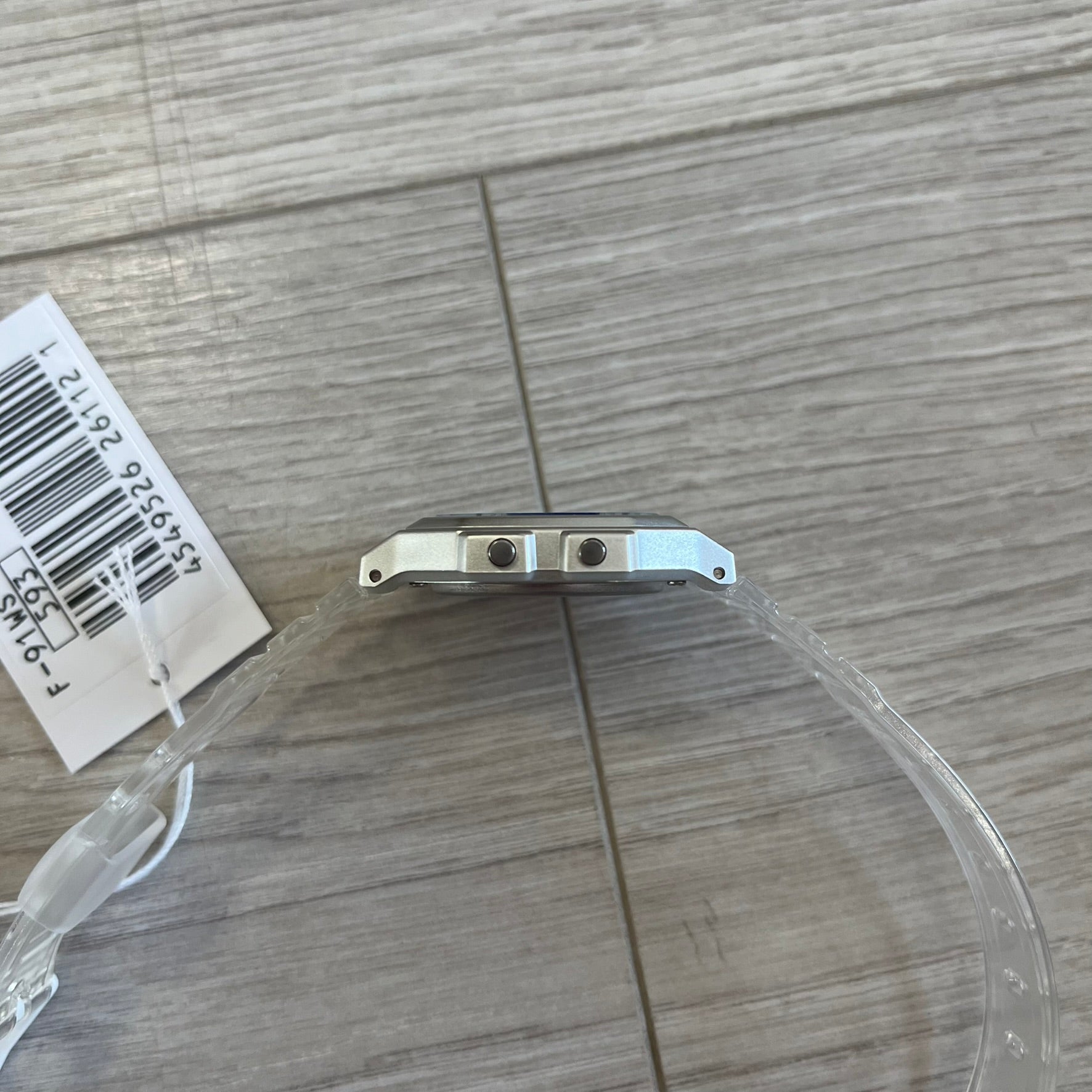 Watch case with a clear plastic cover on a wooden surface