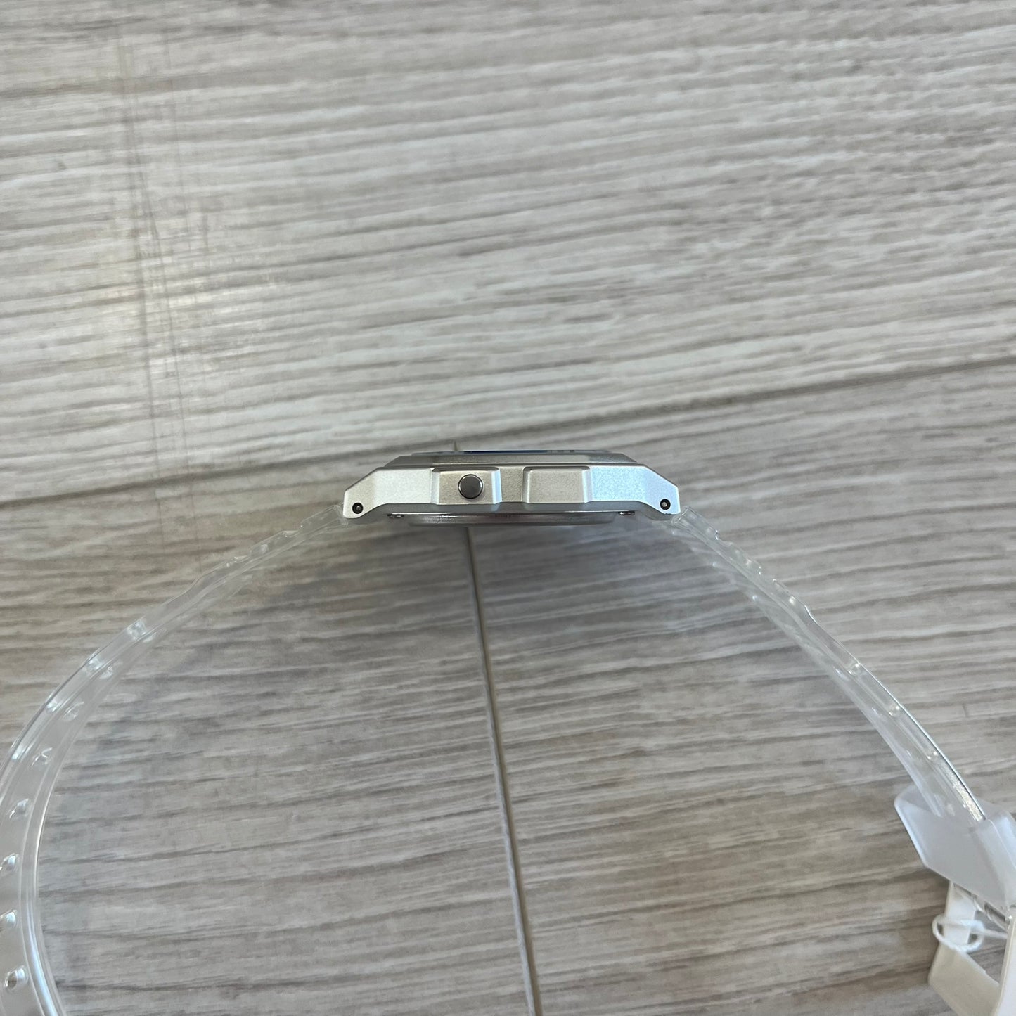 Clear plastic cover on a metallic object with a wooden surface background