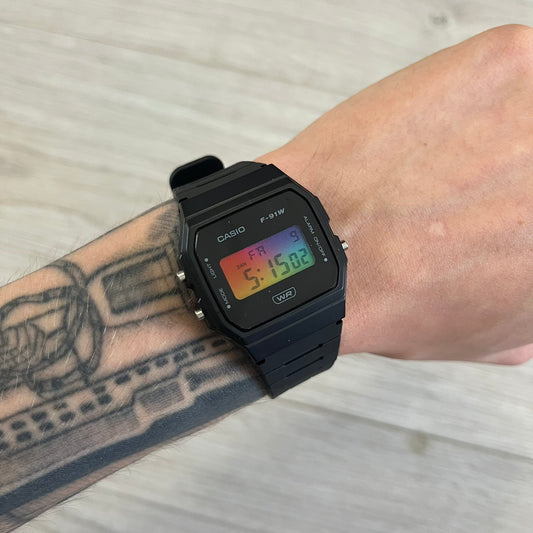 Black Casio digital watch on a wrist with tattoos