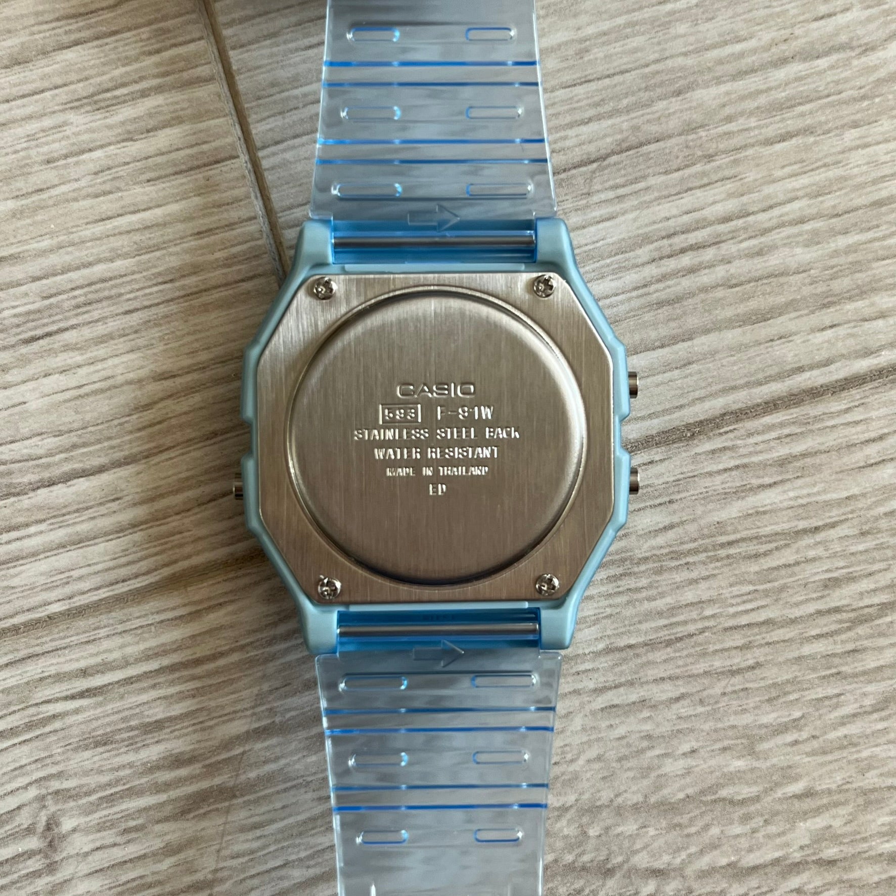 Casio watch with blue strap on a wooden surface