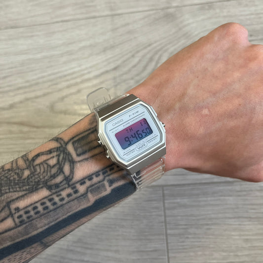 Person wearing a Casio digital watch on a wooden surface