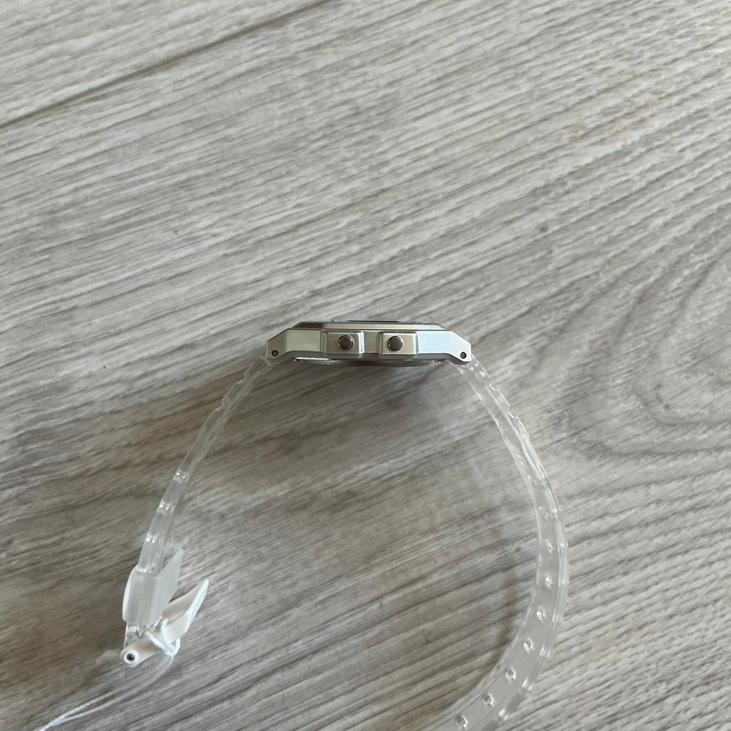 Clear plastic tube with metal fitting on a wooden surface