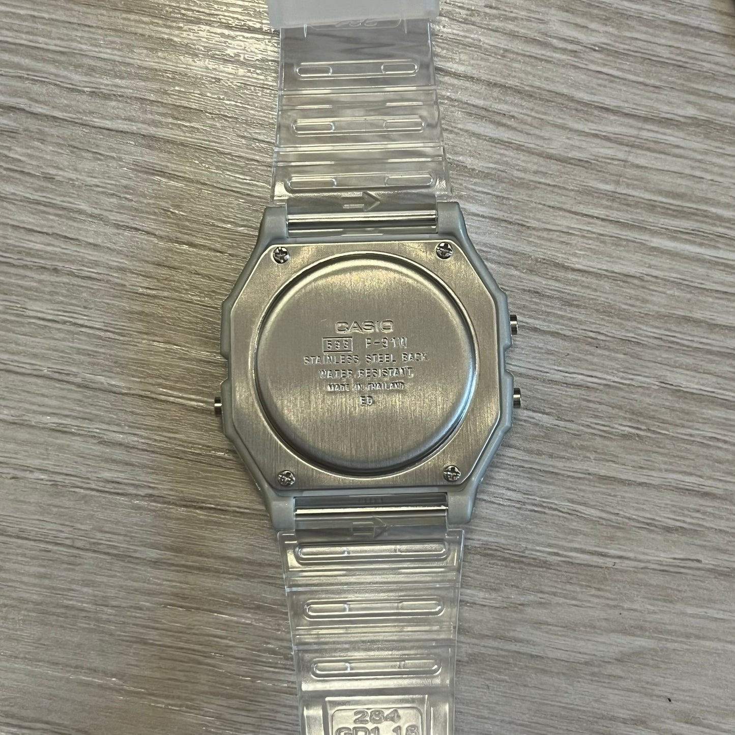 Clear Casio watch on a wooden surface