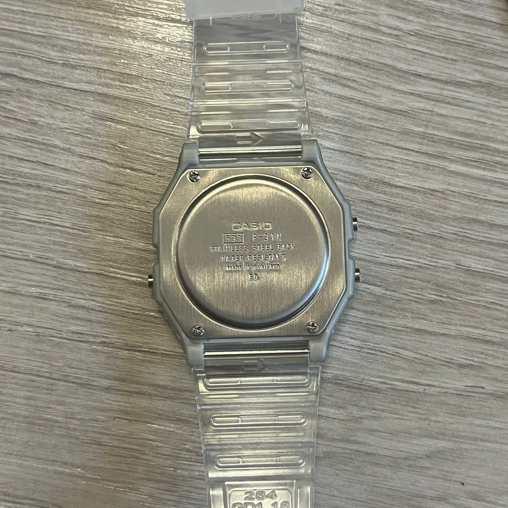 Clear Casio watch on a wooden surface