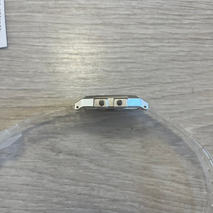 Metallic object on a round, transparent surface with a wooden background