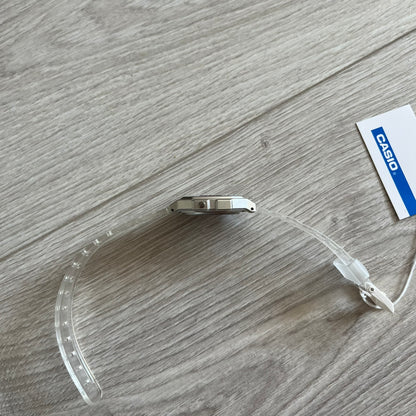 Casio watch case with clear plastic cover on a wooden surface