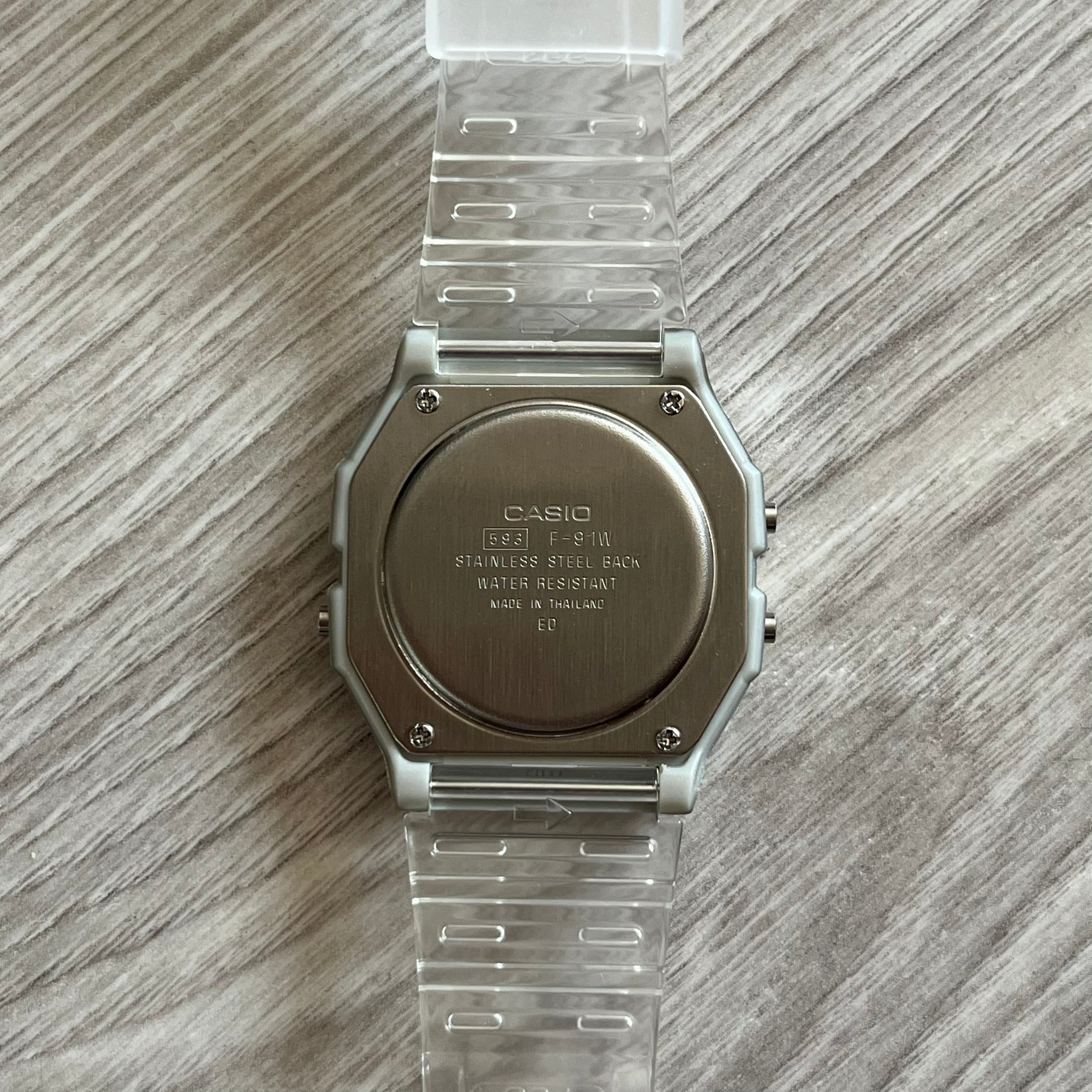 Casio watch with clear strap on a wooden surface