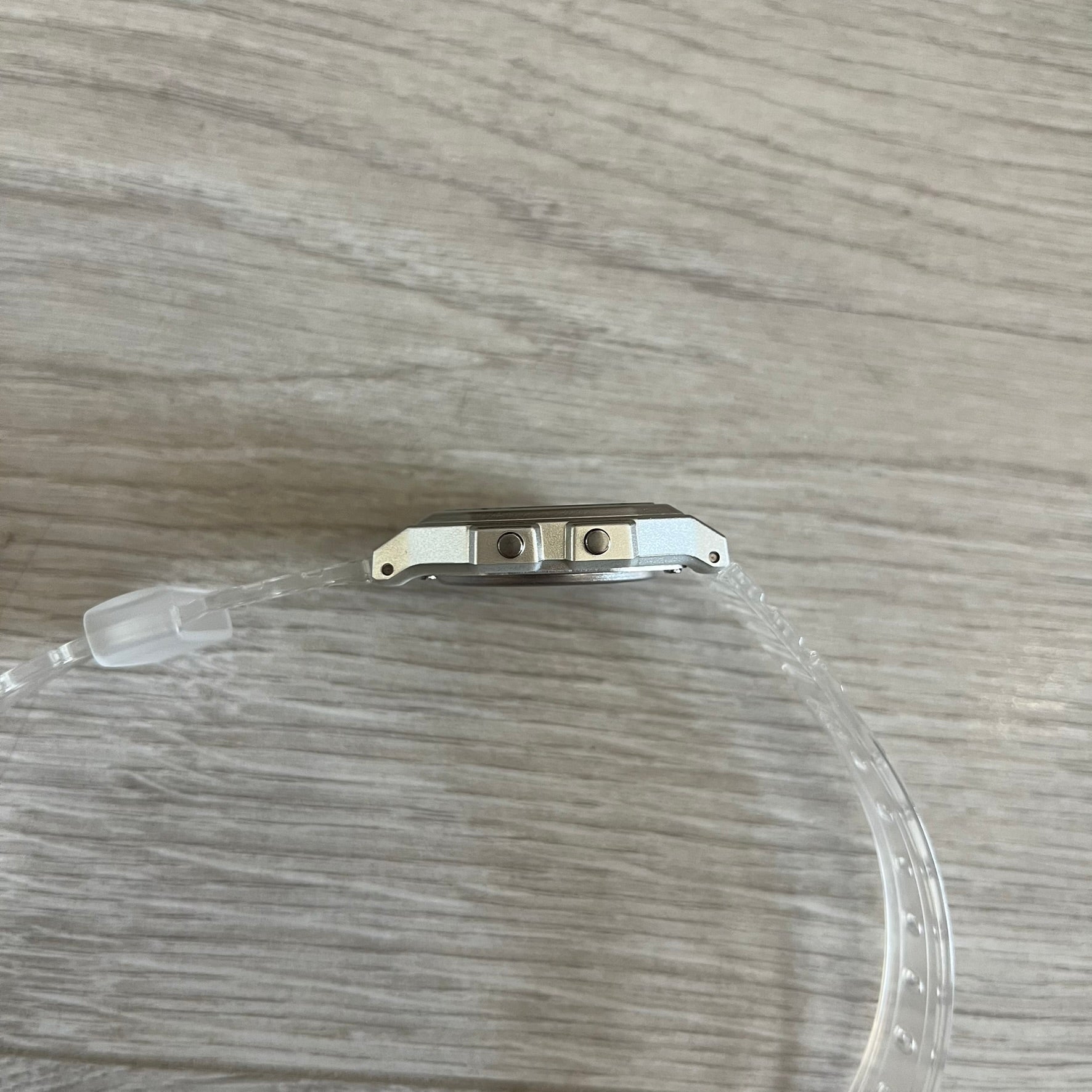 Clear plastic tube with metal clip on a wooden surface