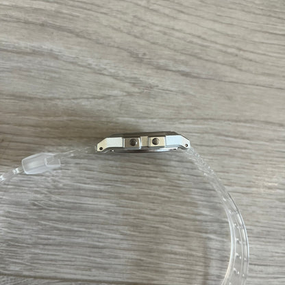 Clear plastic tube with metal clip on a wooden surface
