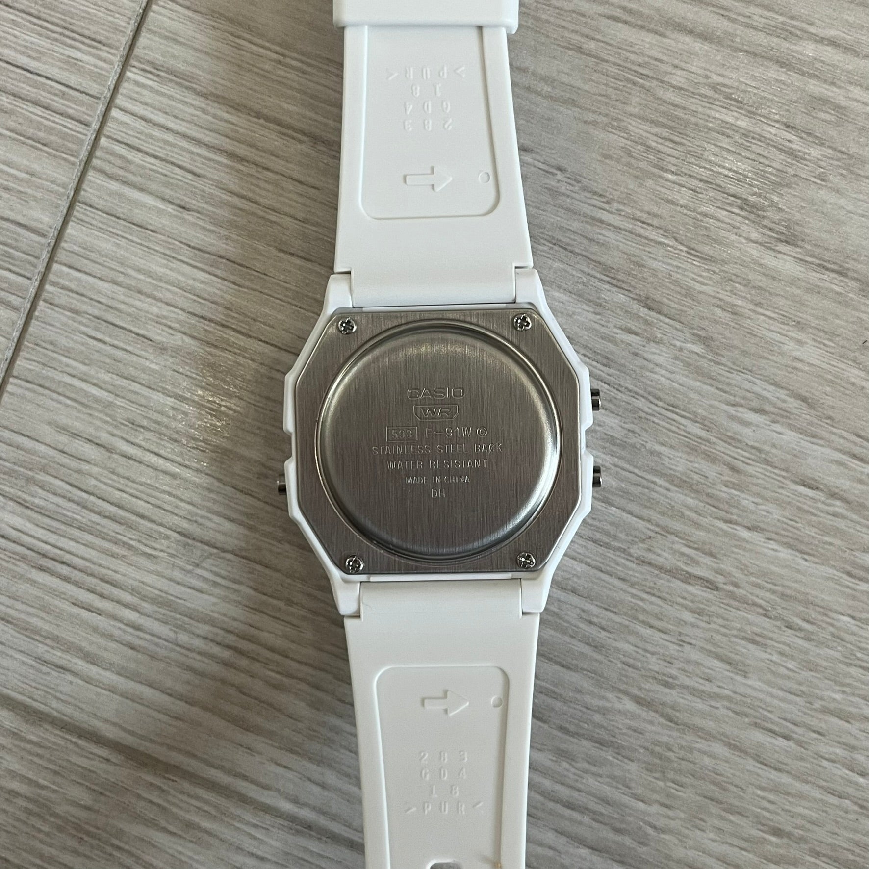 White Casio watch on a wooden surface
