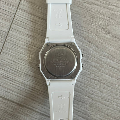 White Casio watch on a wooden surface