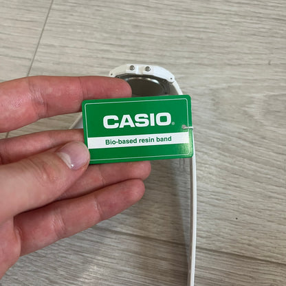 Hand holding a Casio bio-based resin band on a wooden surface