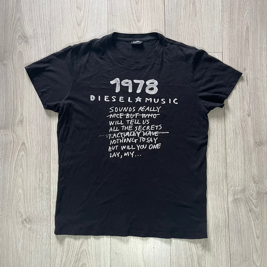 Black t-shirt with white text on a wooden surface