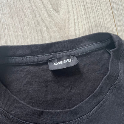 Black t-shirt with a Diesel label on a wooden surface