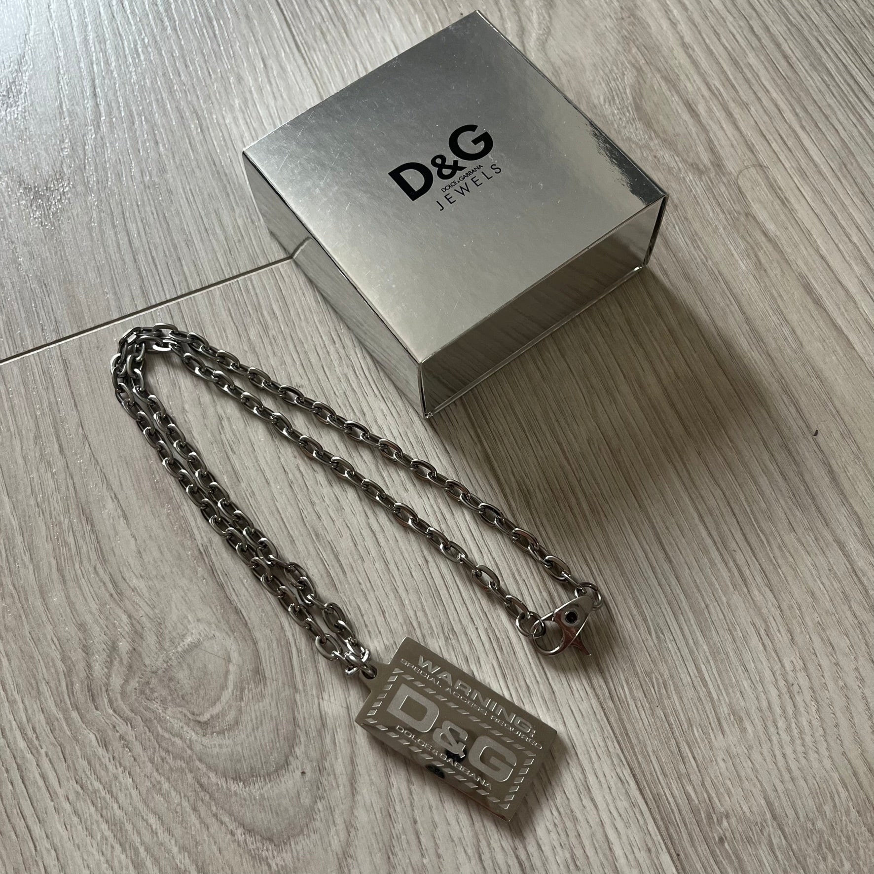 D&G jewelry box with chain on a wooden surface