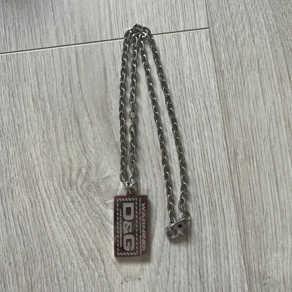 Silver chain with a rectangular tag on a wooden surface