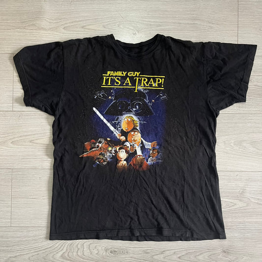 Black t-shirt with 'Family Guy It's a Trap!' graphic on a wooden surface