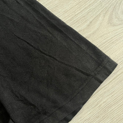 Close-up of black pants on a beige surface